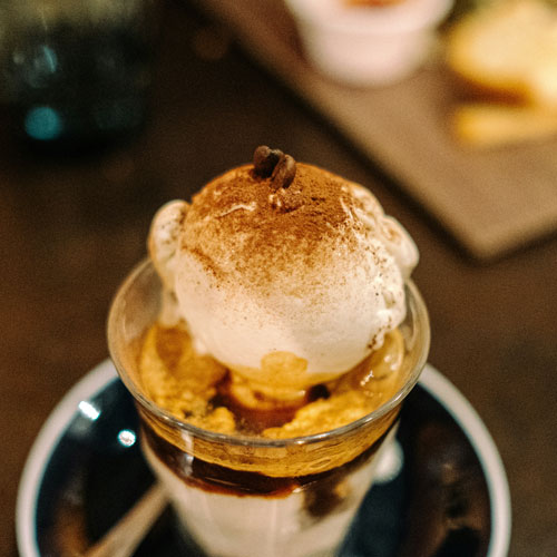 Ein kleines Glas Espresso mit einer Kugel Vanilleeis und Zimt